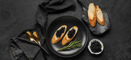Tasty bruschettas with black caviar on dark background