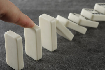 hand with domino effect on white
