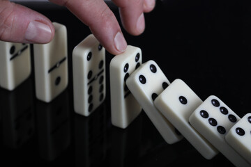hand with domino effect on white