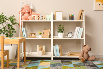 Interior of children room with toys, pictures, table and shelving units
