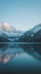 Fototapeta premium Snow-Capped Mountains Reflected in Calm Lake Waters