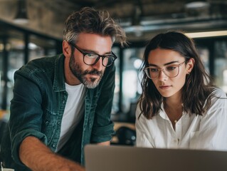 Focused marketing manager and sales executive collaborating closely on a laptop screen, concept for data analysis presentation, sales strategy review and collaborative project planning