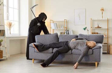 Grim reaper in dark cloak and hood standing behind unconscious or lifeless man lying on gray couch...