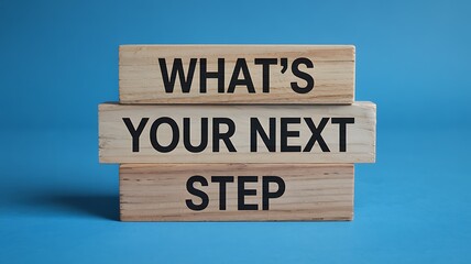 Wooden blocks stacked with the motivational phrase whats your next step in bold black lettering against a vibrant blue background
