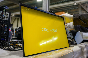 Monitor screen testing process inside an electronics manufacturing plant with quality assurance...