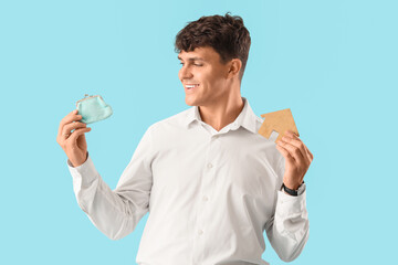 Male real estate agent with wallet and house figure on blue background