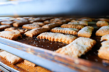 Light and flaky puff pastry cookies cooling on a tray in a cozy bakery setting