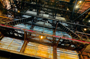 Industrial structure with intricate support beams and vivid lighting at a construction site during...