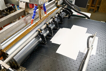 Precision glue applicator in action at a manufacturing facility for seamless paper bonding and...
