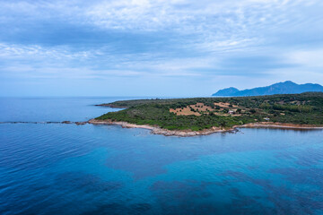 Naklejka premium Aerial view of a rocky coastline, vegetation, and mountains in S