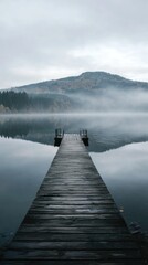 Naklejka premium Misty Morning Lake Pier, Calm Water, Mountain Background, Peaceful Scenery