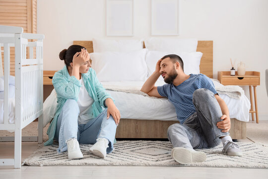 Tired parents with their little baby in crib at home - Powered by Adobe
