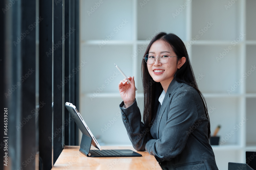 Poster young manager smiling while using a digital tablet and stylus pen, working efficiently in a stylish 
