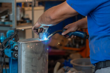 Master replacing of  muffler of exhaust system in car workshop. Car pipe 
exhaust welding