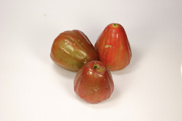 Three very ripe red and crimson water apples isolated on a white background, taken from a three-quarter angle.