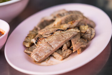 Perfect grilled Thai beef served on pink dish. Close up.