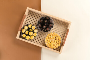 Top view of three jars of Indonesian cookies nastar, kastengel, and chocolate arranged in a woven...
