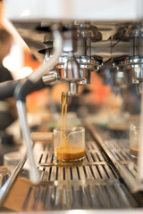 A barista extracts a rich espresso shot from a professional coffee machine.