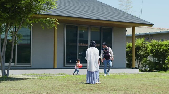 平屋の庭で遊ぶ家族