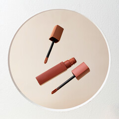 A reddish-brown liquid lipstick with the applicator wand removed from the tube, positioned...