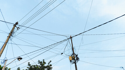 High tension electrical pole structure captured in daylight with clear blue sky as background. Energy supply infrastructure, modern utility tower design seen in rural and industrial zones.