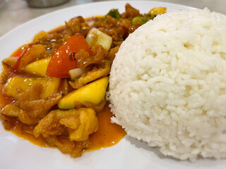 Sweet and sour chicken with rice close up background. Stock photo.