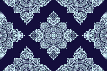 Traditional Thai art seamless floral pattern bold white colored damask style motif suitable for wallpaper, cloth, textile, tile and fabric design isolated over blue background.