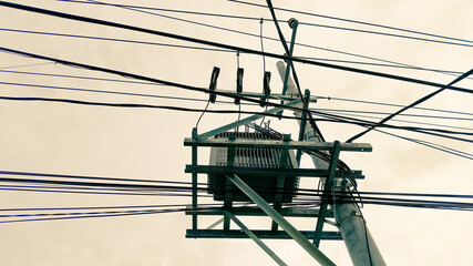 Tall electricity tower structure under cloudy skies, representing power, industrial design, and...