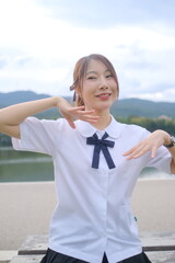 A girl in a white shirt and black skirt is posing for a picture. A Student girl concept