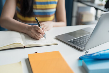 Asian Woman Student Focused on Online Learning with Laptop in Home.