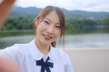 A girl with a white shirt and blue bow is smiling for a picture. A Student girl concept