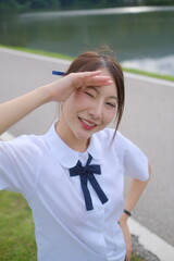 A girl wearing a white shirt and a blue bow tie is looking up at the sky. A Student girl concept