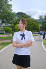 A woman in a school uniform is standing on a sidewalk. A Student girl concept