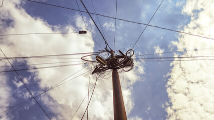 Isolated high voltage transmission tower standing against vivid blue background. Strong vertical...