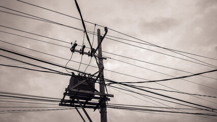 Energy distribution pole rising beneath dark clouds, emphasizing strong industrial composition,...
