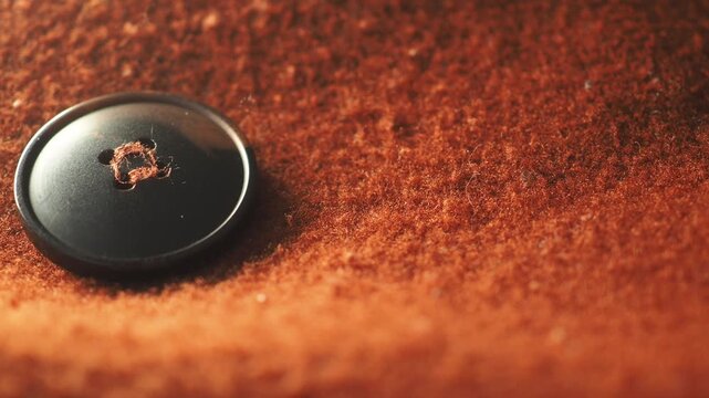 Close-up of a button on brown fabric