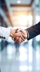 Close-up of a handshake between two businesspeople in a blurred office background