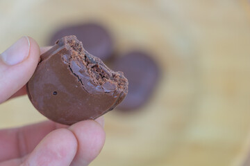 Bitten Chocolate Candy Held in Hand with Blurred Background