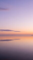 Naklejka premium Soft pastel hues paint a serene horizon as a tranquil sky meets its perfect reflection on the calm, mirror-like waters, evoking peace and solitude.