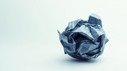 Crumpled ball of paper on plain background in studio