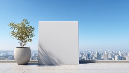 A large blank canvas stands on a rooftop terrace overlooking a sprawling city under a clear blue sky, next to a potted plant casting a shadow