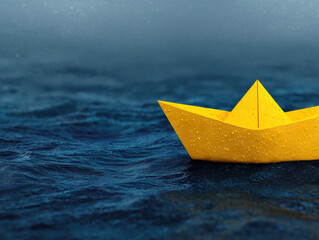 Yellow paper boat floating on rippling water, evoking sense of calm and simplicity
