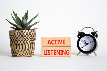 Listen actively symbol. Wooden blocks with words Listen actively. Beautiful white background with...