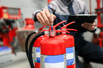 Engineers are checking and adjusting fire extinguishers in fire protection systems.