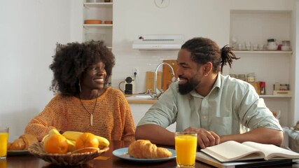 Young couple enjoying breakfast and conversation in kitchen - Powered by Adobe