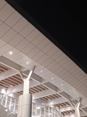Modern architectural ceiling structure with illuminated panels and supporting columns at night, showcasing clean lines and contemporary design.