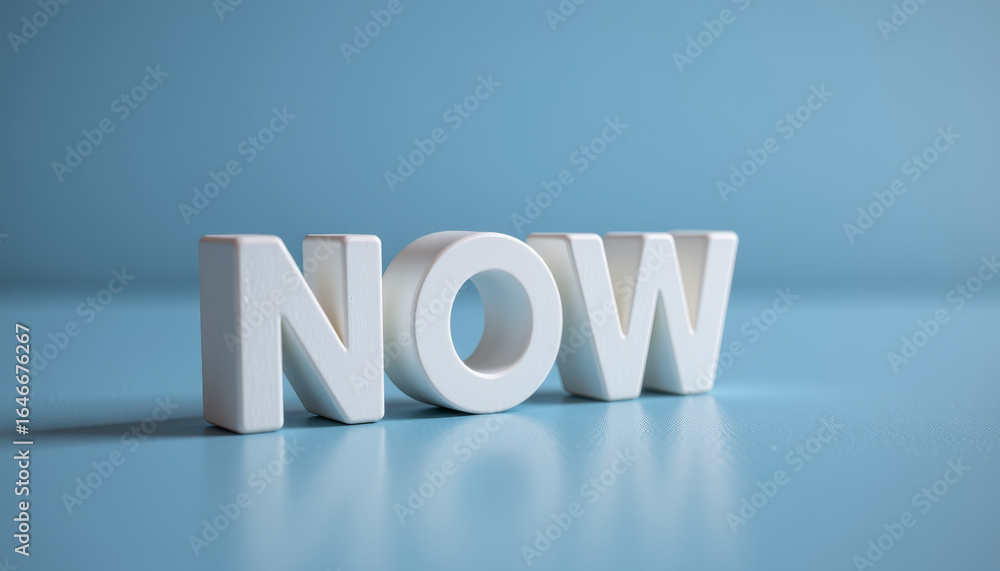 Poster NOW word in white block letters on blue surface with soft shadow and reflection, conveying urgency and focus in calm setting