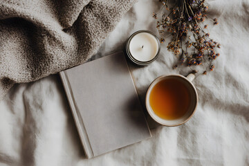 Cozy afternoon with warm tea, a good book, and calming candle creating a peaceful hygge atmosphere...