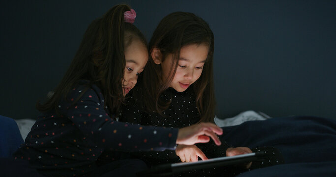 Relax, tablet and kids in bedroom for movie, film or video on app for entertainment together. Bonding, children and sisters watching show on streaming website with digital technology in home at night
