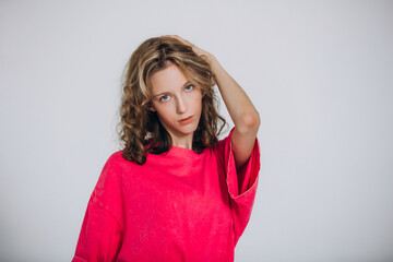 The model is a young beautiful girl in a pink T-shirt in a studio on a white background